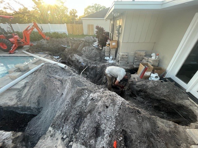 Underground plumbing work beside a home