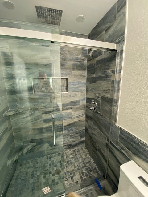 Blue-gray tiled shower with sliding glass door