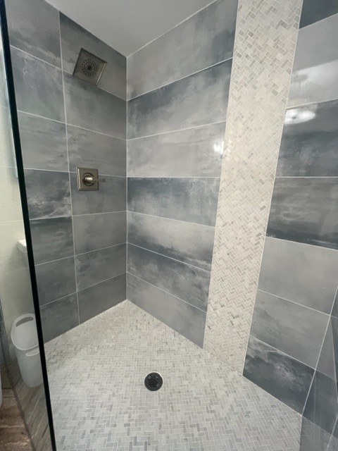 Gray tiled shower with mosaic accent